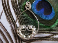 Een hanger bestaand uit twee gespiegelde spiralen, gebaseerd op de Gulden Snede. De spiralen en pareltjes symboliseren groei en ontwikkeling; ze zijn verbonden in liefde en uiteindelijk als twee identieke hangers te dragen door moeder en dochter.